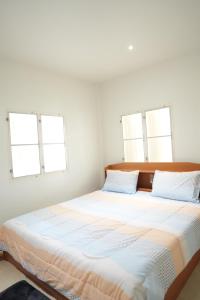 a bedroom with a large bed with two windows at Tara Resort in Nathon