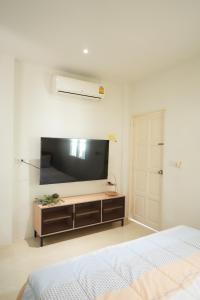 a bedroom with a large flat screen tv on the wall at Tara Resort in Nathon