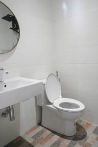 a white bathroom with a toilet and a sink at Tara Resort in Nathon