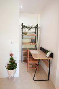 a room with a desk and a christmas tree at Tara Resort in Nathon