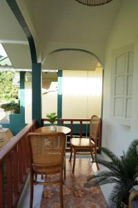a porch with a table and chairs on a balcony at Tara Resort in Nathon