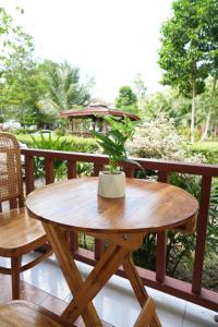 a wooden table with a potted plant on a balcony at Tara Resort in Nathon