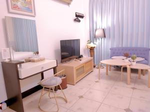 a living room with a television and a room with a couch at 旅行者之家精緻漫旅-附免費停車位需預約 in Hualien City