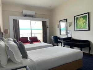 a hotel room with two beds and a desk at Seaview Suite at Rainbow Paradise in Tanjung Bungah