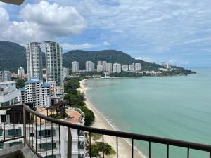 Seaview Suite at Rainbow Paradise في تانجونغ بونغاه: اطلالة على شاطئ ومباني والمحيط
