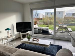 uma sala de estar com um sofá e uma grande janela em Sea-Senses.com/Blue LaGoon em Oostduinkerke