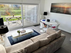 uma sala de estar com um sofá e uma mesa em Sea-Senses.com/Blue LaGoon em Oostduinkerke