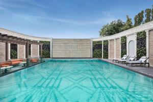 an indoor swimming pool with chairs and a swimming house at Radisson Blu Hotel GRT, Chennai International Airport in Chennai