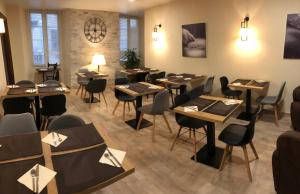 restauracja ze stołami i krzesłami w pokoju w obiekcie Hôtel du Nord w mieście Corte