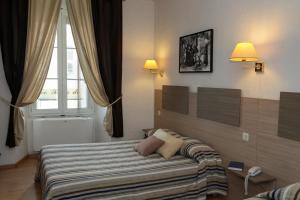 sypialnia z łóżkiem i oknem w obiekcie Hôtel du Nord w mieście Corte