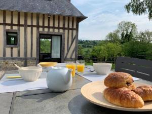 - une table avec une assiette de pain et de jus d'orange dans l'établissement Maisonnette au calme, 15 kms Honfleur/Deauville, à Les Authieux-sur-Calonne