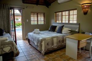- une chambre avec un lit, une table et des fenêtres dans l'établissement Melsetter's Guesthouse, à Bloemfontein