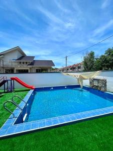 una piscina con tobogán y un parque infantil en Villa D'Razna - Luxury 5-bedroom Villa with private pool en Kuala Terengganu