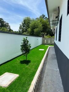 a small tree in a yard next to a building at Villa D'Razna - Luxury 5-bedroom Villa with private pool in Kuala Terengganu