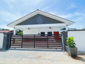 una pequeña casa con una puerta delante de ella en Villa D'Razna - Luxury 5-bedroom Villa with private pool en Kuala Terengganu