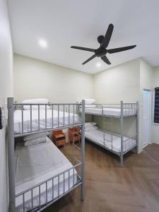 Habitación con 3 literas y ventilador de techo. en Villa D'Razna - Luxury 5-bedroom Villa with private pool, en Kuala Terengganu