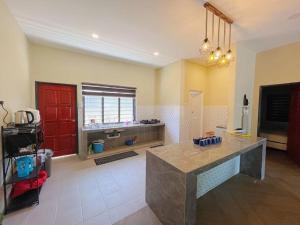 a kitchen with a counter and a red door at Villa D'Razna - Luxury 5-bedroom Villa with private pool in Kuala Terengganu