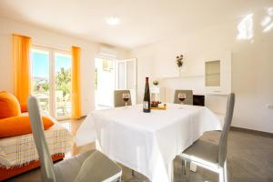 ein Wohnzimmer mit einem weißen Tisch und einer Flasche Wein in der Unterkunft Reful Top modern facility with large terrace or balcony in Metajna