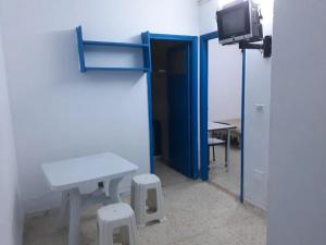 a room with a table and a tv and a table and stool at Sidi Mansour Route Touristique in Sfax
