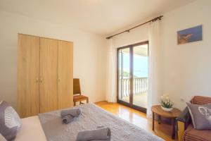 Schlafzimmer mit einem Bett und einer Tür zu einem Balkon in der Unterkunft Lucija with mountain and seaview in Metajna