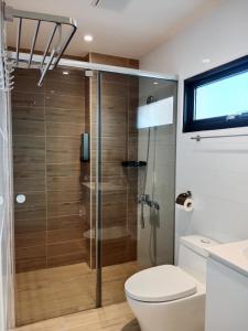 uma casa de banho com um WC e uma cabina de duche em vidro. em Ocean Guest House em Magong