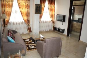 sala de estar con sofá y mesa de cristal en Jaria Apartments en Accra