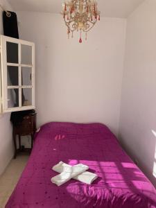 - un lit violet avec 2 serviettes blanches dans l'établissement Studio Marsa, à La Marsa