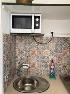 a kitchen counter with a sink and a microwave at Studio Marsa in La Marsa