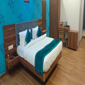 Hotel Golden Palm في باتنا: غرفة نوم بسرير كبير بجدران زرقاء