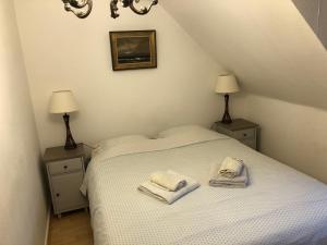 cosy-rooms-party-villa في Bierges: غرفة نوم بسرير ابيض عليها مناشف