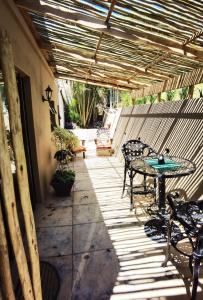 une terrasse couverte avec une table et des chaises. dans l'établissement Calla—Cottage, à Ballito