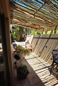 une terrasse avec des chaises et une pergola en bois. dans l'établissement Calla—Cottage, à Ballito