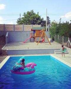 Une fille est en train de monter sur un tube intérieur dans une piscine dans l'établissement Vila Kraljev Breg Fruška Gora, à Čortanovci