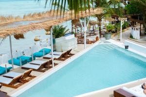 - une vue sur la piscine avec des chaises et une plage dans l'établissement Coral Rocks Hotel & Restaurant, à Jambiani