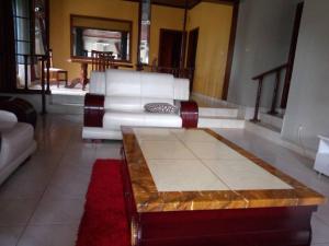 a living room with a white couch and a coffee table at Nuc-Fey Lodging in Kigali