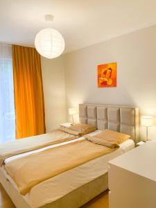 a bedroom with a large bed with two lamps at Sunny apartment in Bečići