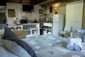a living room with a bed and a kitchen at Melsetter's Guesthouse in Bloemfontein