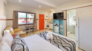 a living room with a bed and a kitchen at Across Country Motor Inn in Dubbo