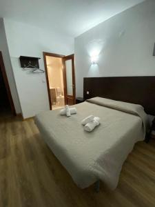 um quarto com uma cama grande e toalhas em Caçula, Alojamento Local em Torre de Moncorvo