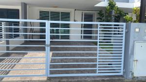 een witte poort voor een huis bij Klia Redza Homestay Kota Warisan Malay only in Sepang