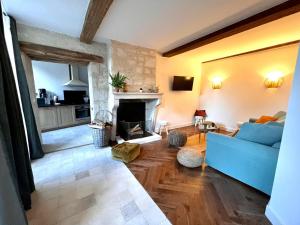 a living room with a blue couch and a fireplace at Chambres Privées des HAMY au coeur du parc national in Arc-en-Barrois