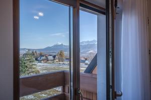 an open door to a balcony with a view of mountains at Willa na Grani in Zakopane