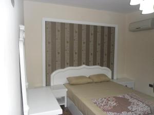 a small bedroom with a bed with a white headboard at Apartment at Milsa Nasr City Building No 8 in Cairo
