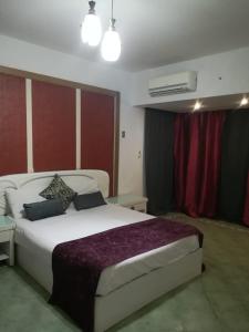 1 dormitorio con 1 cama blanca grande en una habitación en Apartment at Milsa Nasr City Building No 8, en El Cairo