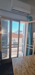 a room with a view of a balcony with windows at Bee Hostel Paphos in Paphos