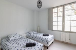 a bedroom with two beds and a window at Chez Mat et Gab proche centre ville in Saumur