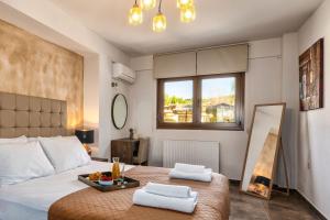 een slaapkamer met een bed met twee handdoeken erop bij Palmrise Luxury Villas by Travel Pro Services - Nea Skioni Halkidiki in Nea Skioni