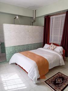 a bedroom with a large bed and a window at Sislink Hotel in Nairobi