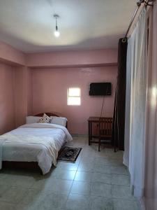 a bedroom with a bed and a television in it at Sislink Hotel in Nairobi