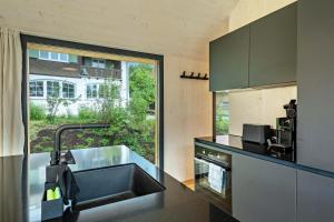 a kitchen with a sink and a large window at Tiny House Lachen in Wangen im Allgäu